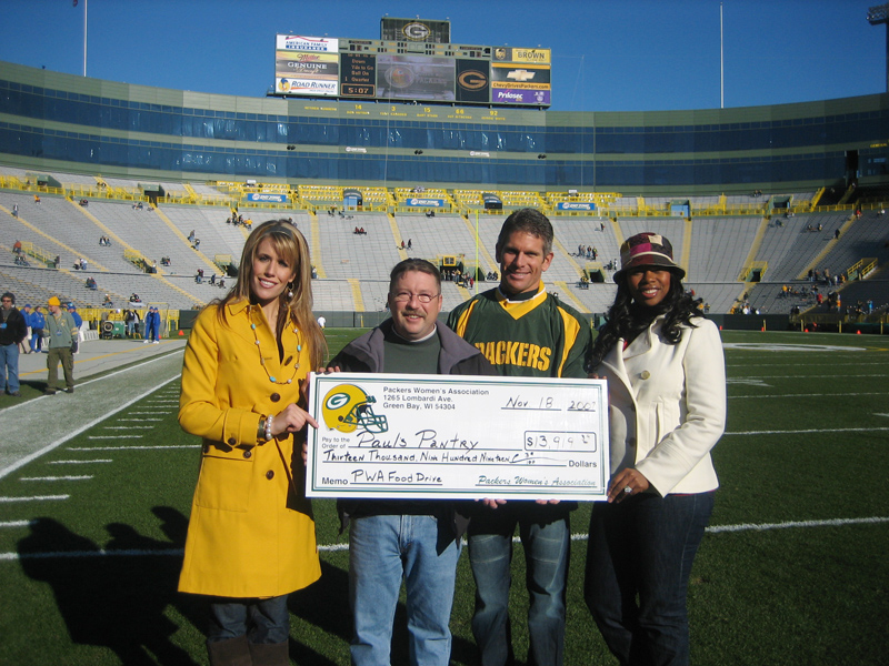Laura Hawk presenting a charity contribution from the Packers Women's Association