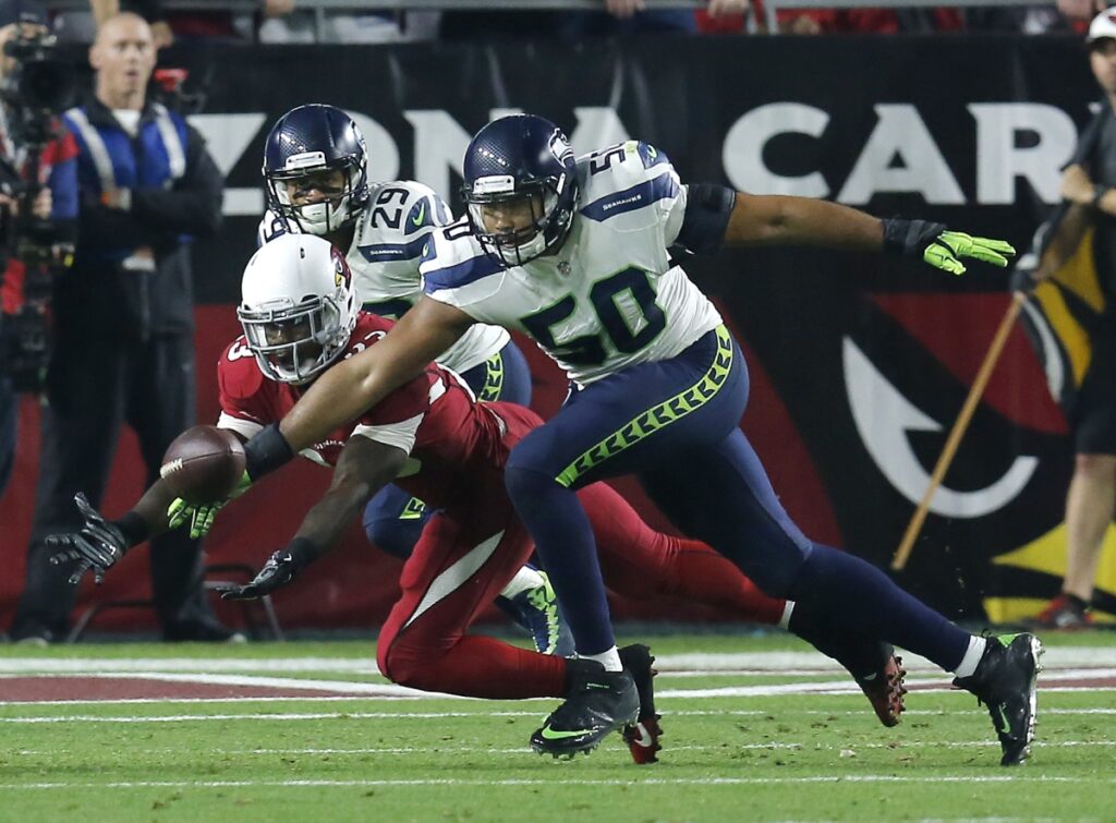 AP Image. Seattle LB KJ Wright displays his rare length with this pass deflection against Arizona.