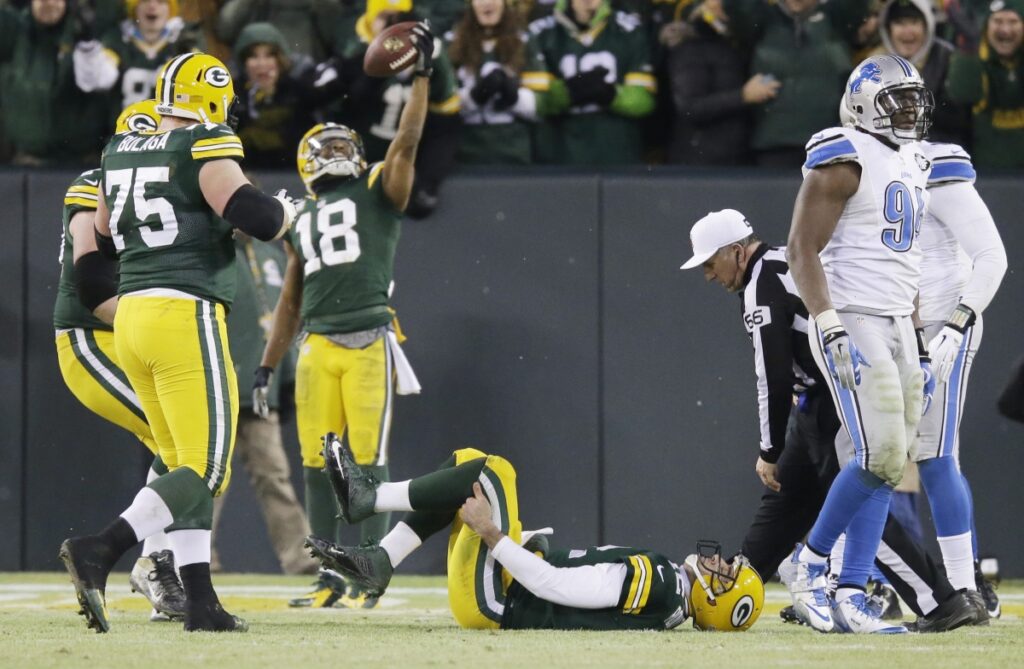 Randall Cobb celebrates his TD catch vs the Lions as Aaron Rodgers grasps his injured leg.