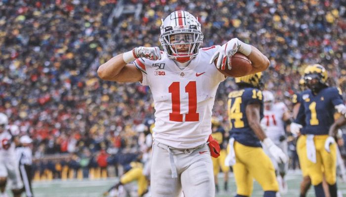 Under the iconic arches of 'The Big House', Michigan Stadium, in 2019, Austin Mack electrifies the atmosphere with an exuberant celebration after scoring a spectacular touchdown